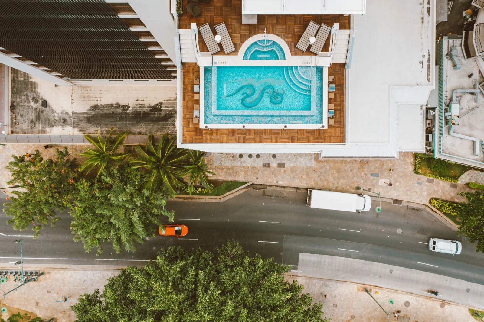 Aerial shot of a rooftop pool and city street with greenery and vehicles. The pool service business plan: sections that matter